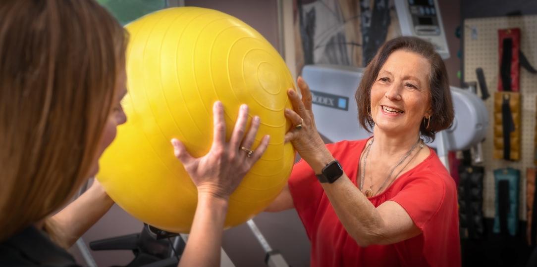 a joyful resident doing rehab with a trainer